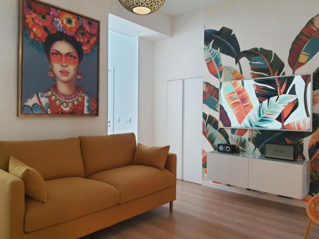 里斯本Exotic Fusion: Coffee & Radio的客厅配有沙发和墙上的绘画