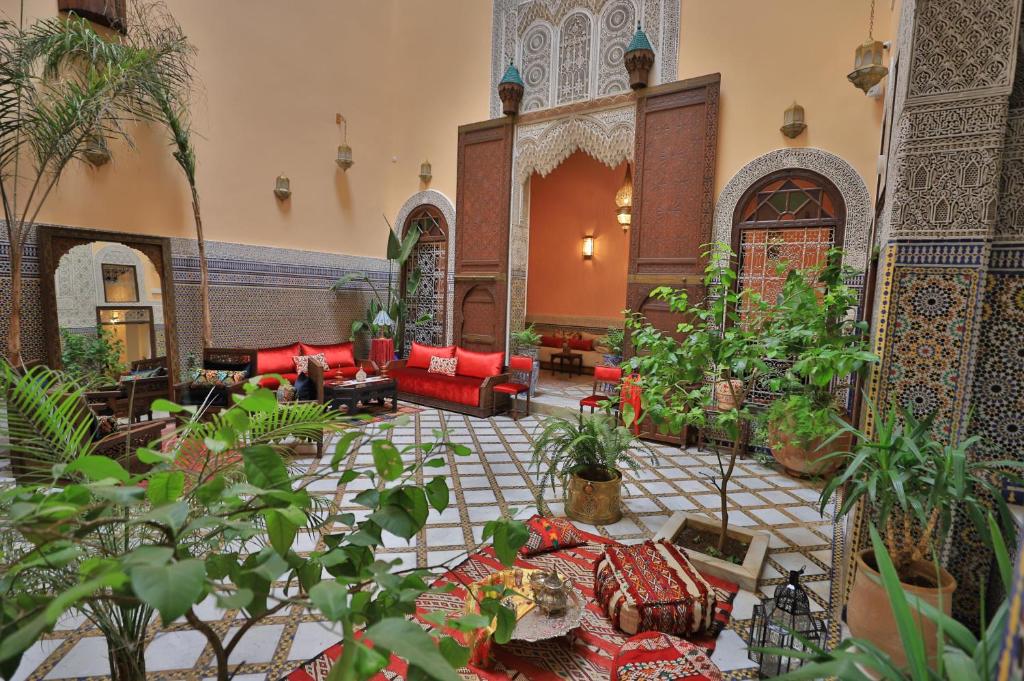 非斯Riad Moulaydriss et Giacomo的客厅配有红色沙发和植物