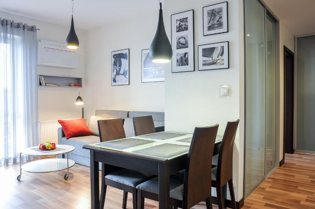 什切青斯塔卡公寓- 河滨的用餐室以及带桌椅的起居室。