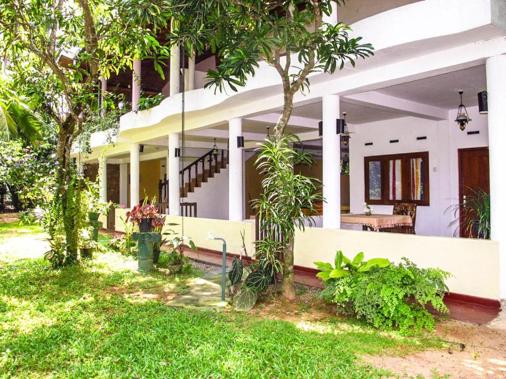 阿鲁特伽马C-Lanka Guest House的前面有树木和草地的房子