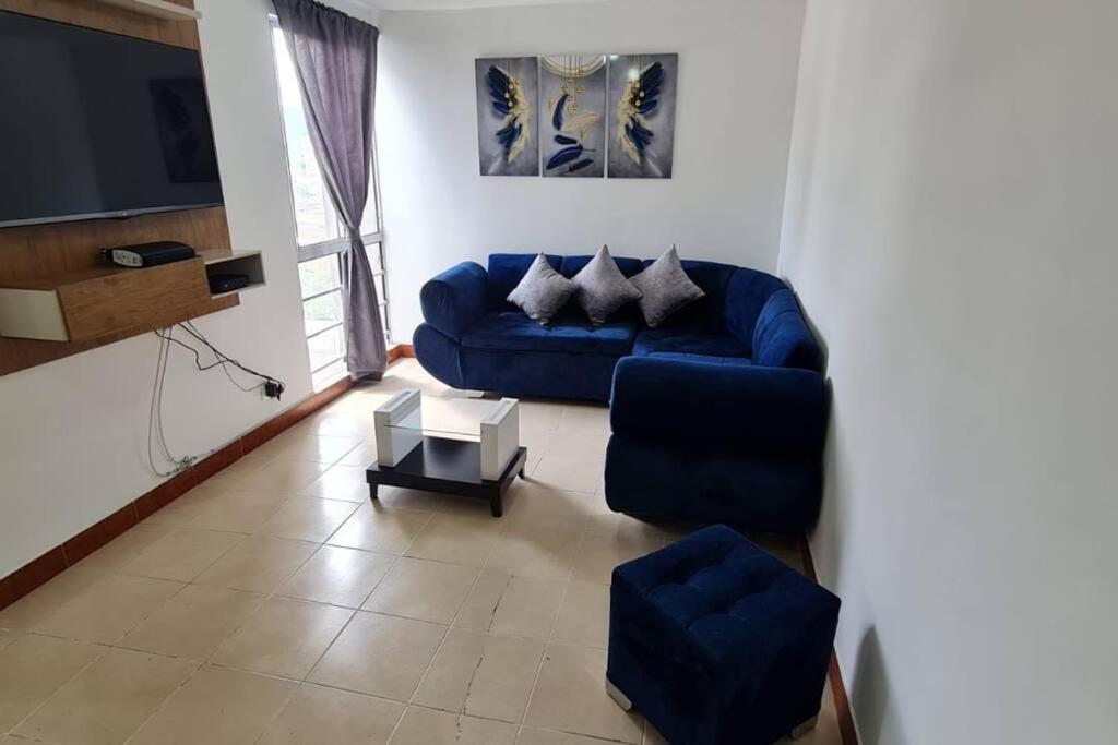 麦德林Hermoso Apartamento en excelente ubicación.的客厅配有蓝色的沙发和电视