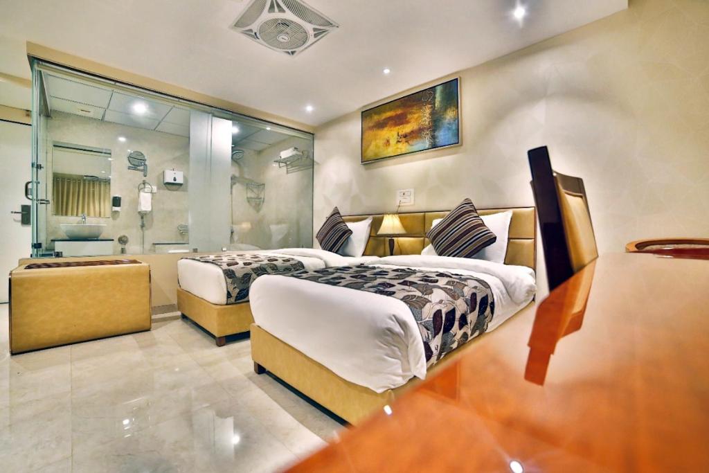 苏拉特Hotel Kings Heritage Surat的一间带两张床的大卧室和一间浴室