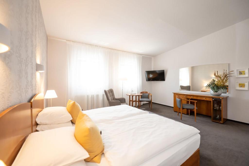 ZeithainHotel Moritz an der Elbe的配有一张床和一张书桌的酒店客房