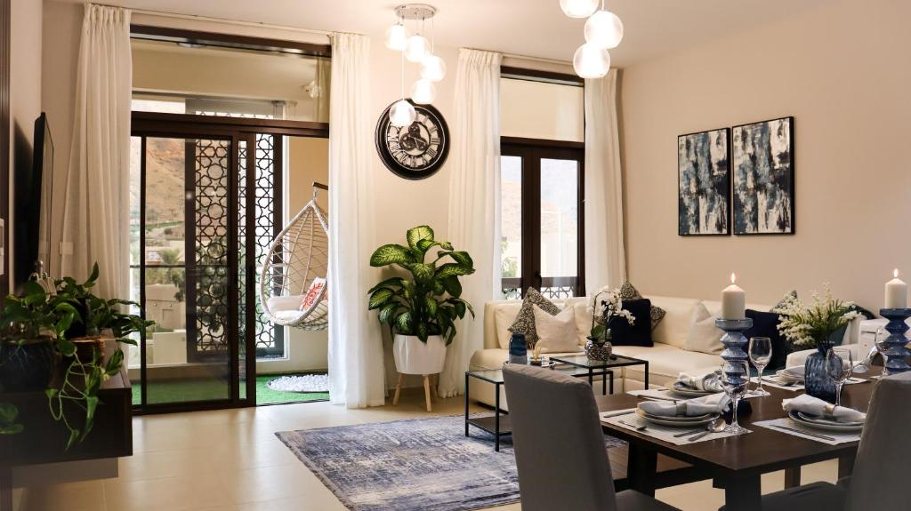 马斯喀特Stylish Apartment with a Jacuzzi (Park&Pool View)的用餐室以及带桌椅的起居室。