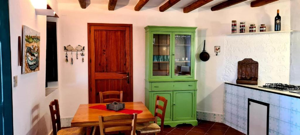 菲利库迪岛Villa Chiara的厨房配有桌子和绿色橱柜。