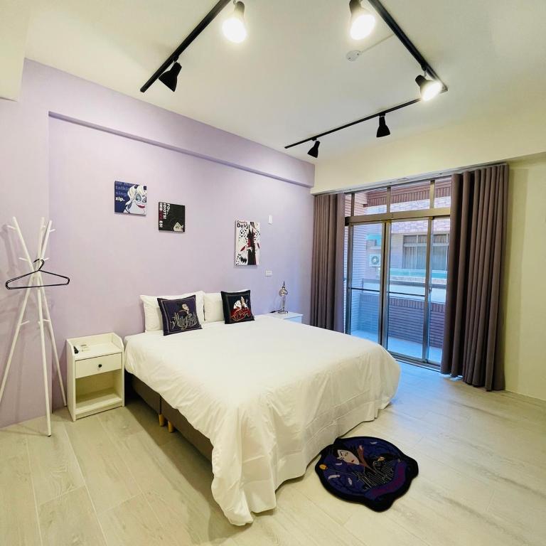 台南唐揚十二街的卧室设有一张白色大床和一扇窗户。
