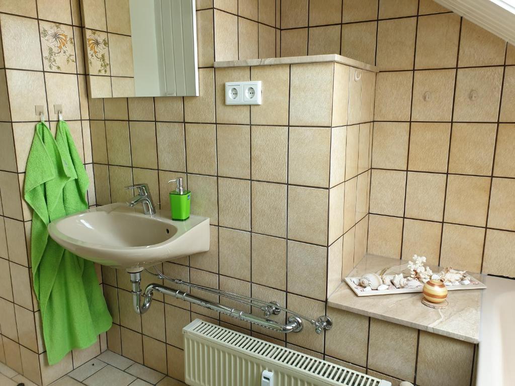 索恩堡Apartment, Boxspringbett, ruhige Lage, Kassel Nähe的一间带水槽和绿毛巾的浴室