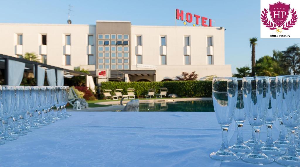 San Giorgio in Bosco波斯塔77酒店的坐在酒店前桌边的一排酒杯
