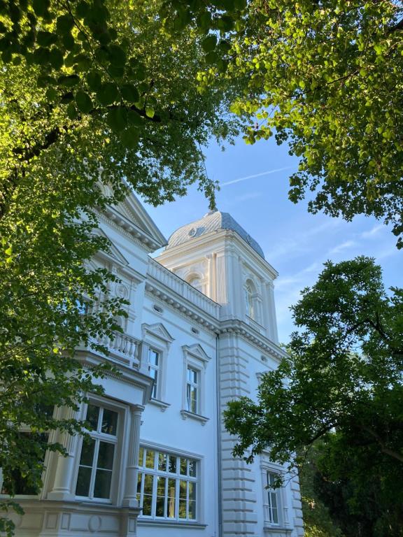 弗罗茨瓦夫Stara Biblioteka的白色的建筑,上面有一个钟楼