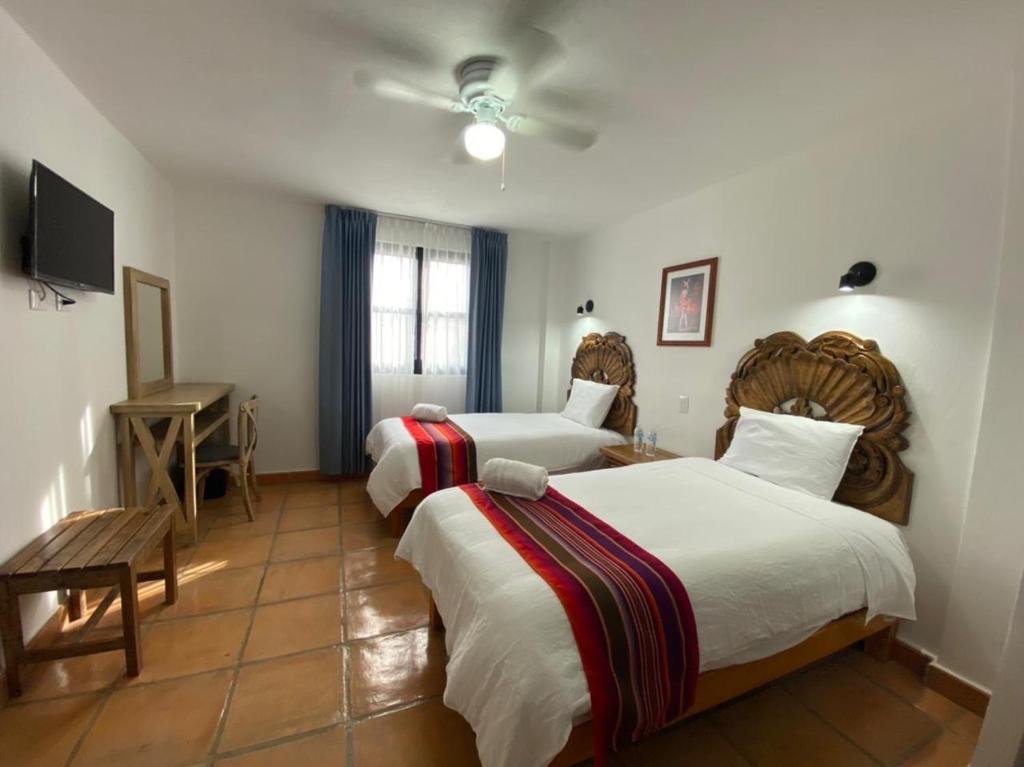 圣米格尔-德阿连德Hotel La Lejona的一间酒店客房,设有两张床和电视