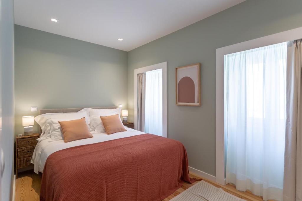 里斯本Ajuda Luxury Appartments的一间卧室设有一张大床和一个窗户。