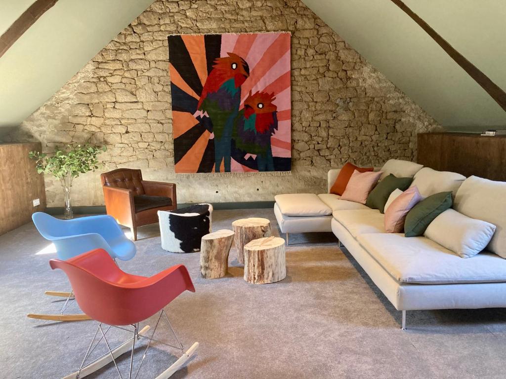 LocmaloEncore une fois, La grande maison的客厅配有沙发、桌子和绘画作品