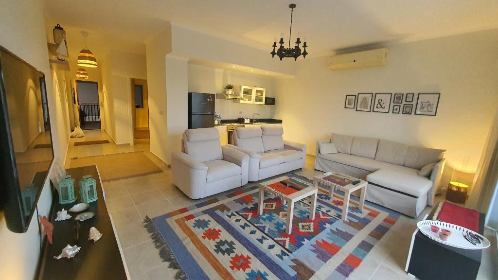 赫尔格达Soma Bay Ambiance - Relaxed Apartment - Next to The Breakers的客厅配有2张白色沙发和地毯。