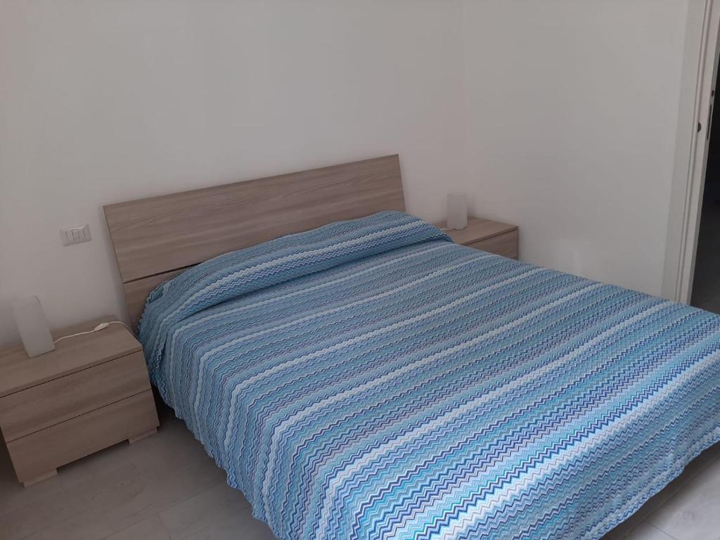 奇维塔韦基亚Home Sweet Home的卧室里一张带蓝色条纹毯子的床