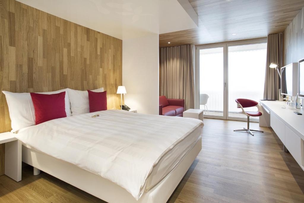 圣加仑桑提斯公园酒店的卧室配有带红色枕头的大型白色床