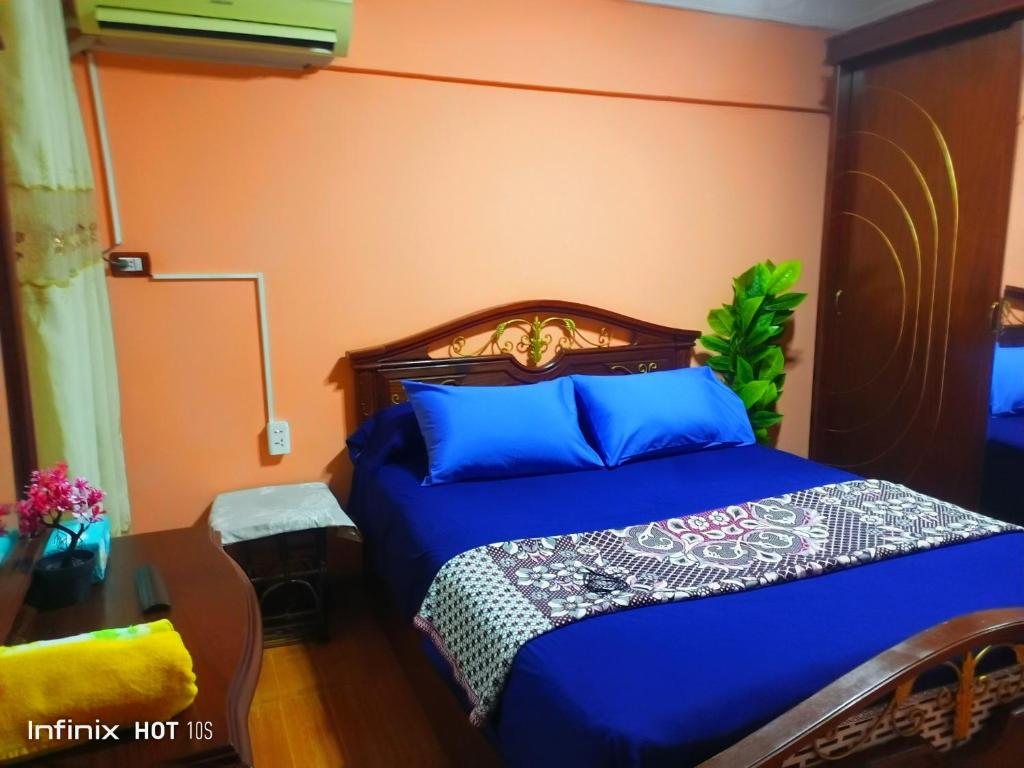 亚历山大Fayrouzat Smoha near the city with open view的一间卧室配有一张带蓝色床单和橙色墙壁的床。