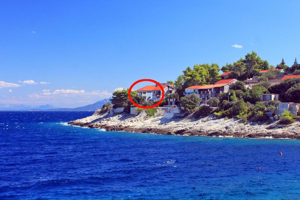 布拉托Apartments by the sea Prigradica, Korcula - 14341的海洋上一座有红圆的岛屿上的房子