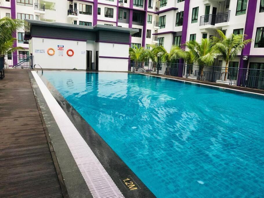 艾尔克如D'sarang Cinta Homestay Swimming Pool Melaka的大楼前的大型蓝色游泳池