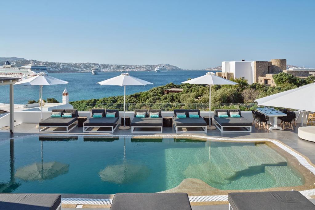 圣斯特凡诺斯Mykonos Princess Hotel的一个带躺椅和遮阳伞的游泳池