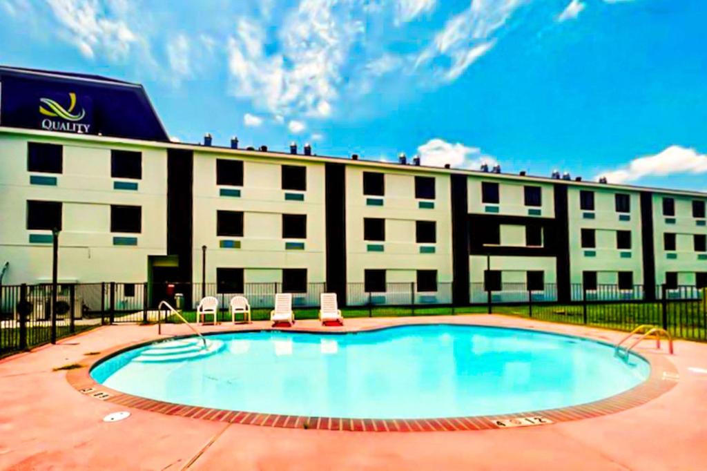 查尔斯湖Quality Inn & Suites Lake Charles的大楼前设有游泳池的酒店