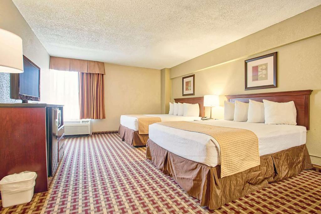 约翰逊城Days Inn & Suites by Wyndham Johnson City的酒店客房设有两张床和电视。