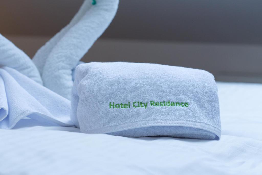 维也纳城居酒店的床上的毛巾,上面写着酒店城市的阻力