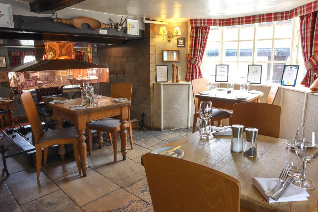 奥克姆The Kings Arms Inn的一间带桌椅的餐厅和一间用餐室