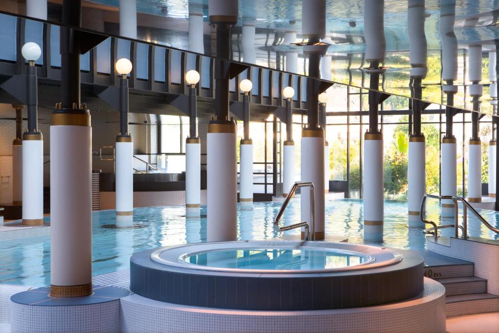因特拉肯维多利亚少女峰温泉大酒店的大楼中央带热水浴池的大型游泳池