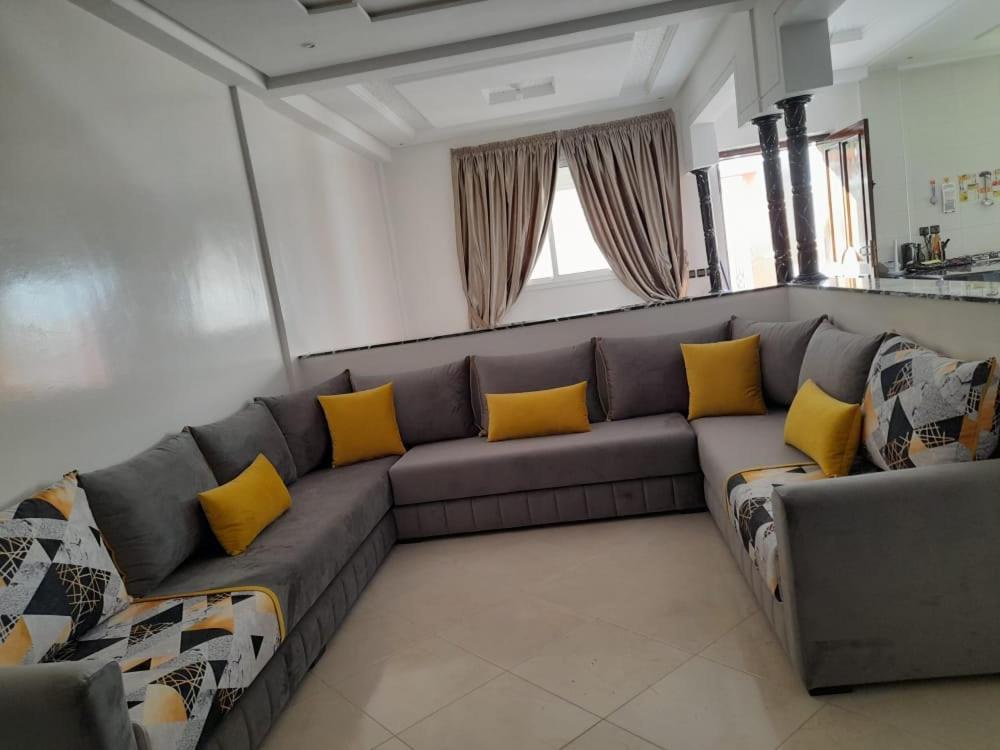 阿加迪尔Amam's Home的客厅配有带黄色枕头的灰色沙发