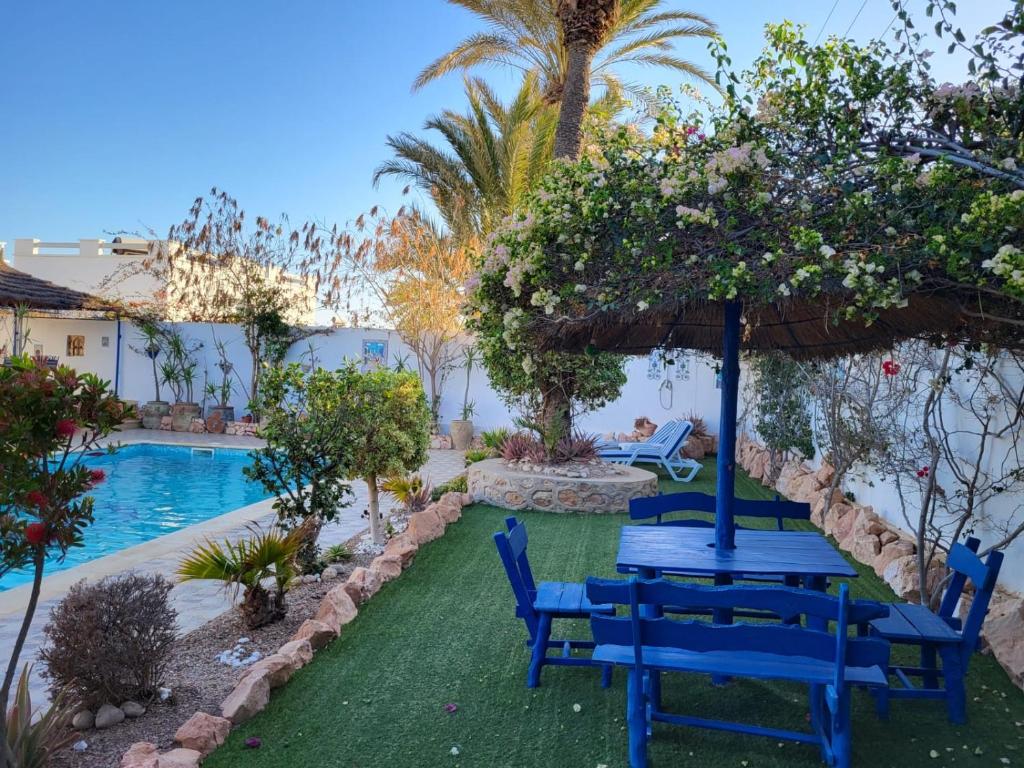 阿格希尔Au jardin d’Aghir: Villa arborée, avec piscine privée sans vis à vis!的游泳池旁的蓝色桌椅