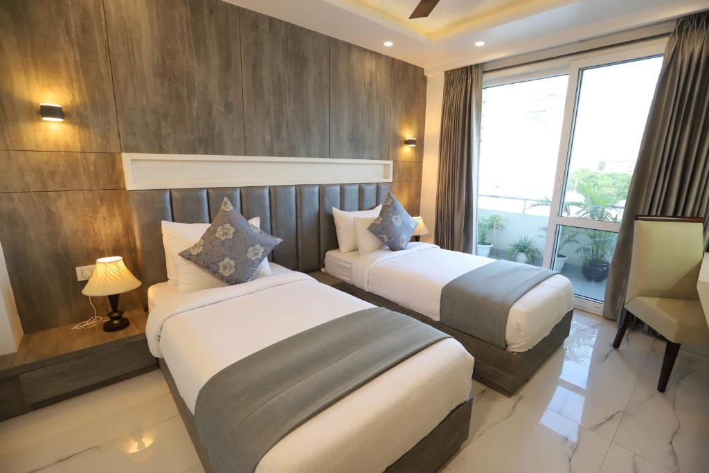古尔冈Hotel Keshav Residency near Medanta Pure Veg的酒店客房设有两张床和窗户。