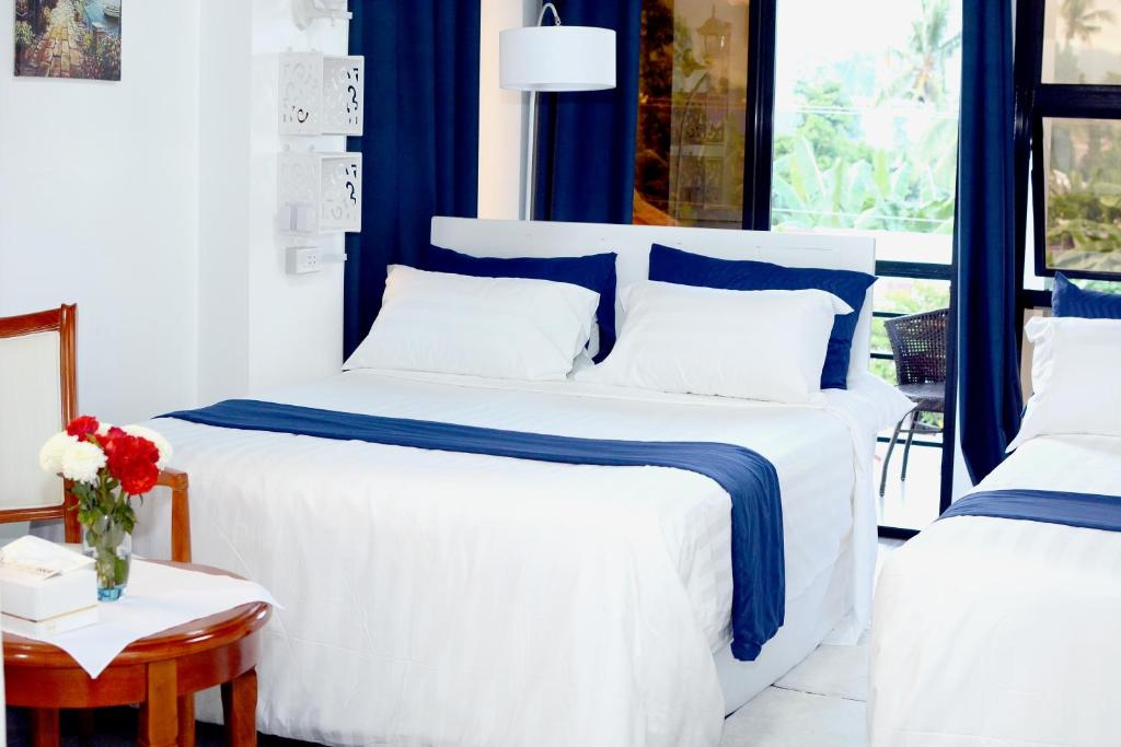 SogodGmb-Arte' Hotel的一间卧室配有两张带蓝白色床单的床