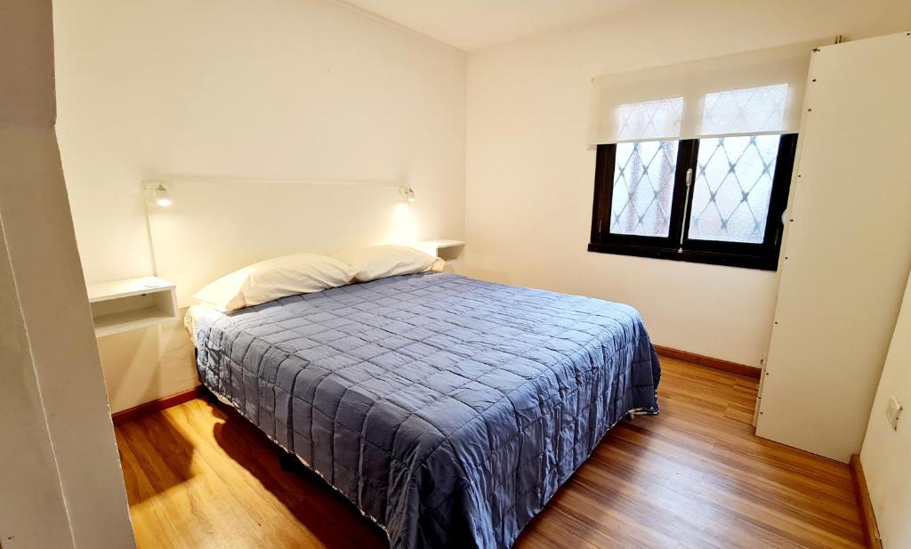 马德普拉塔Hermosa casa PH equipada y con patio. Aestrenar的一间卧室配有一张带蓝色毯子的床和窗户。