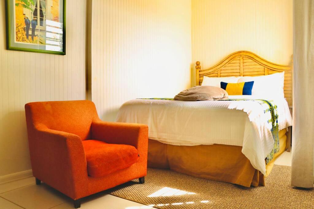 拿撒勒The Northside Cottage的一间卧室配有一张床和一张橙色椅子