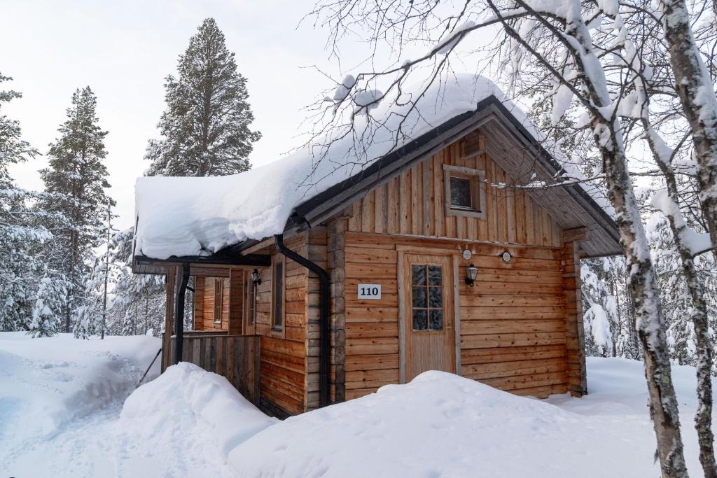 穆奥尼奥Tunturilapin Tuvat的屋顶上积雪的小木屋