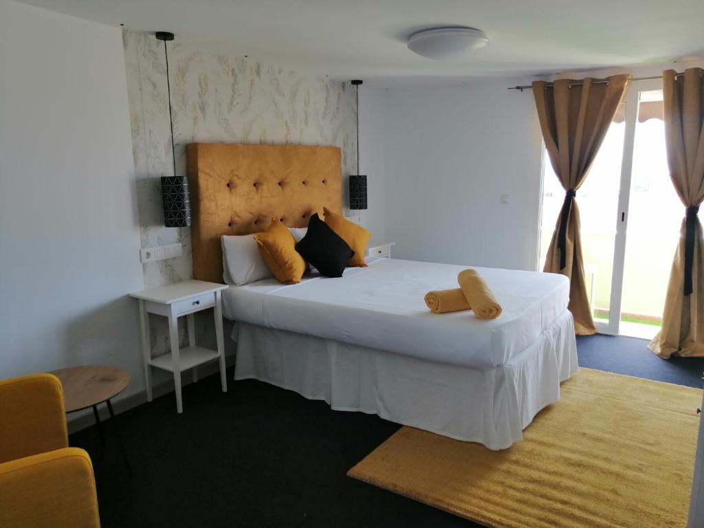 LajitaChabela's water wall的卧室配有一张带黄色枕头的大型白色床。