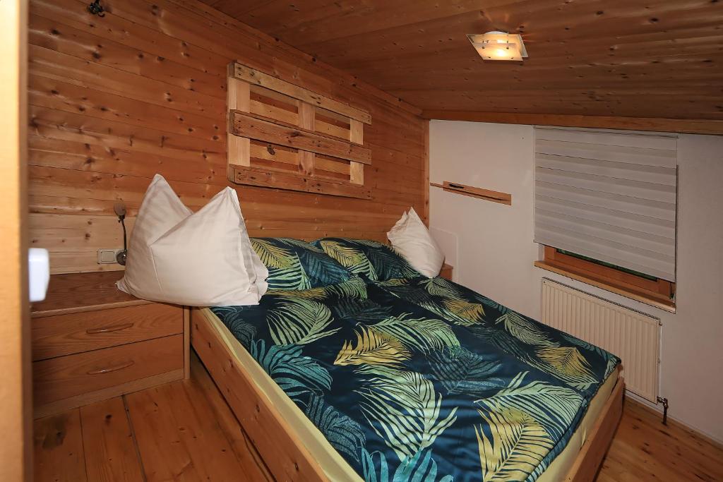 齐勒谷地里德Kuanerhof Wohnung 2-4 Personen的木制客房内的一间卧室,配有一张床