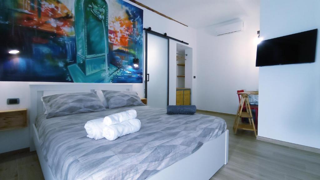 都灵B&B Borgo Vanchiglia的一间卧室配有一张带白色毛巾的床