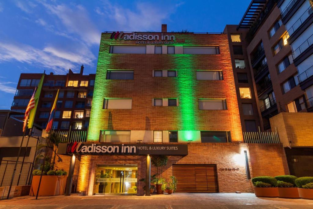 波哥大Hotel Madisson Inn Luxury By GEH Suites的一边有绿灯的建筑