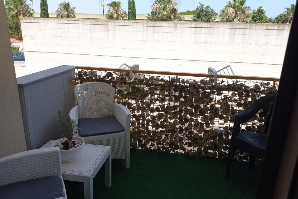 布林迪西Casa vacanza Sofy的阳台配有椅子和带围栏的墙壁