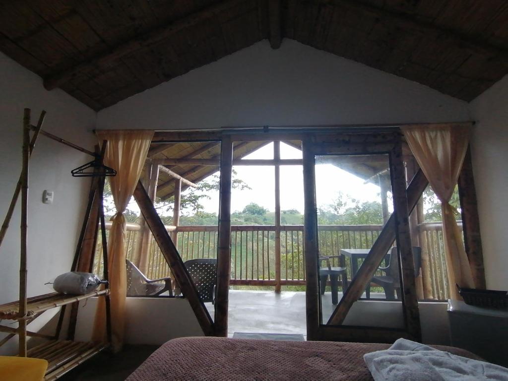 菲兰迪亚Alojamiento rural finca la bendición的卧室设有大玻璃门和阳台