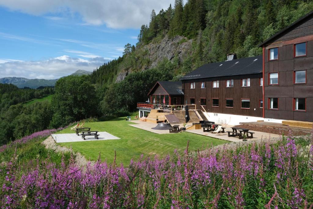 RaulandAustbø Hotell的草和紫色花的建筑