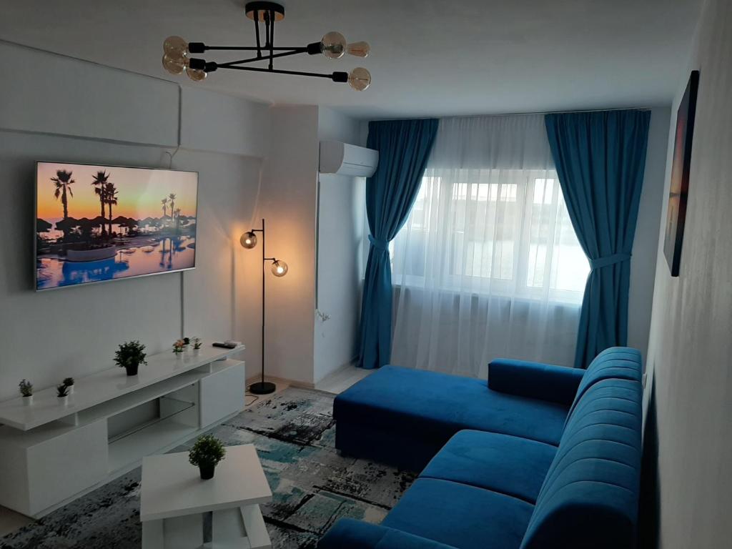 苏利纳Apartament DeltaView Deluxe Sulina的客厅设有蓝色的沙发和窗户。