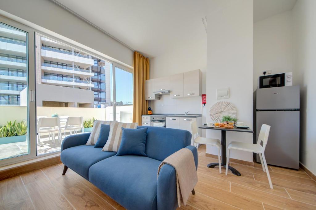 埃尔哥茨拉Marina Suites & apartments - Self catering - by Tritoni hotels的一间带蓝色沙发的客厅和一间厨房