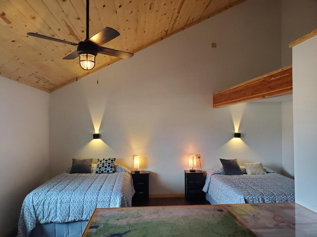 CameronDream Drift Motel的一间卧室配有两张床和吊扇