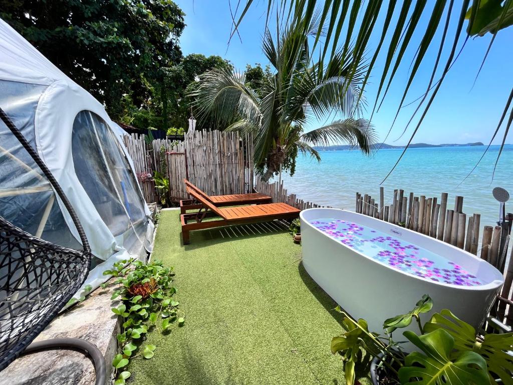 拉威海滩Phuket Signature Glamping的浴缸位于海边的草地上