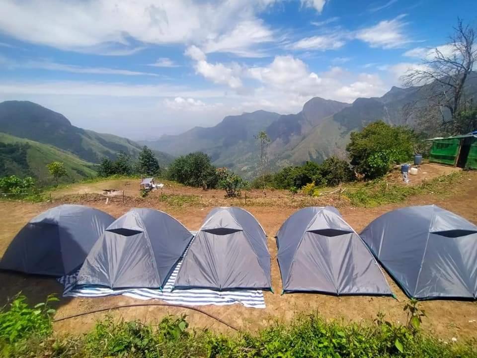 蒙纳Munnar Tent Camping的四座帐篷位于山地的田野中