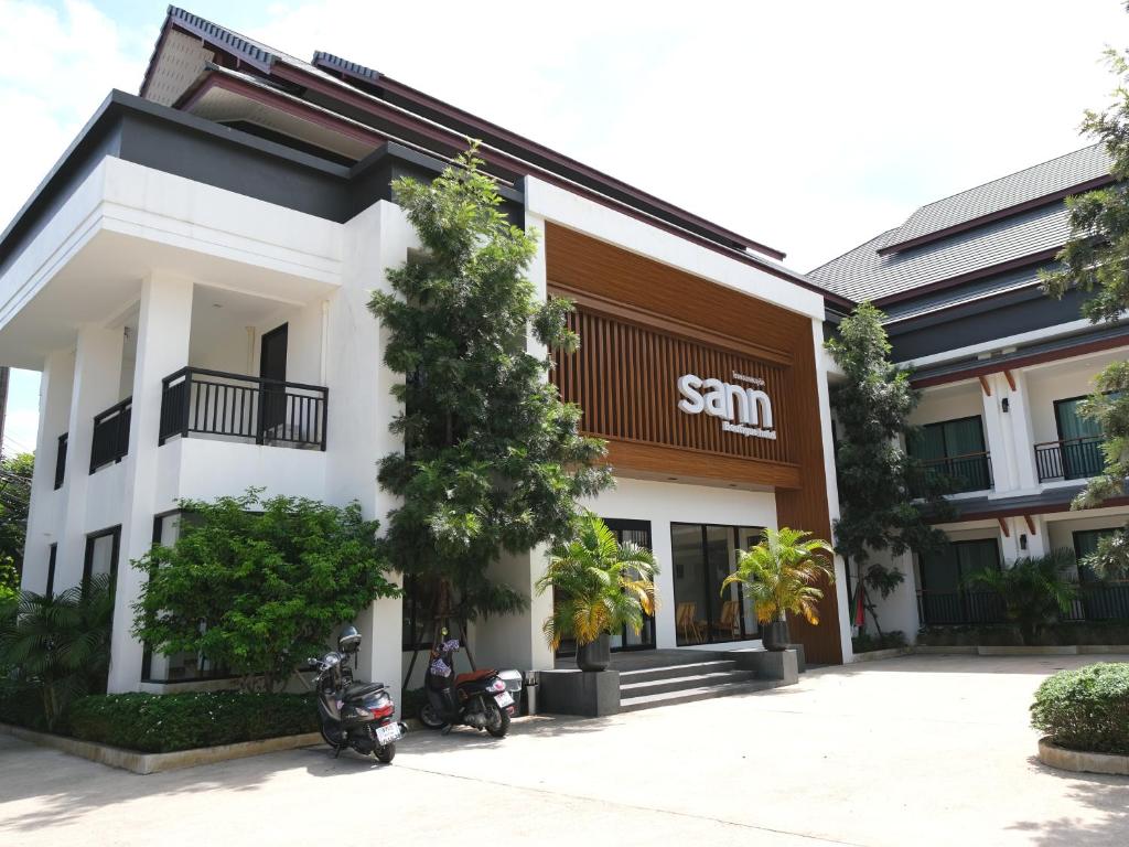 清莱Sann Boutique Hotel的前面有一辆摩托车停放的建筑