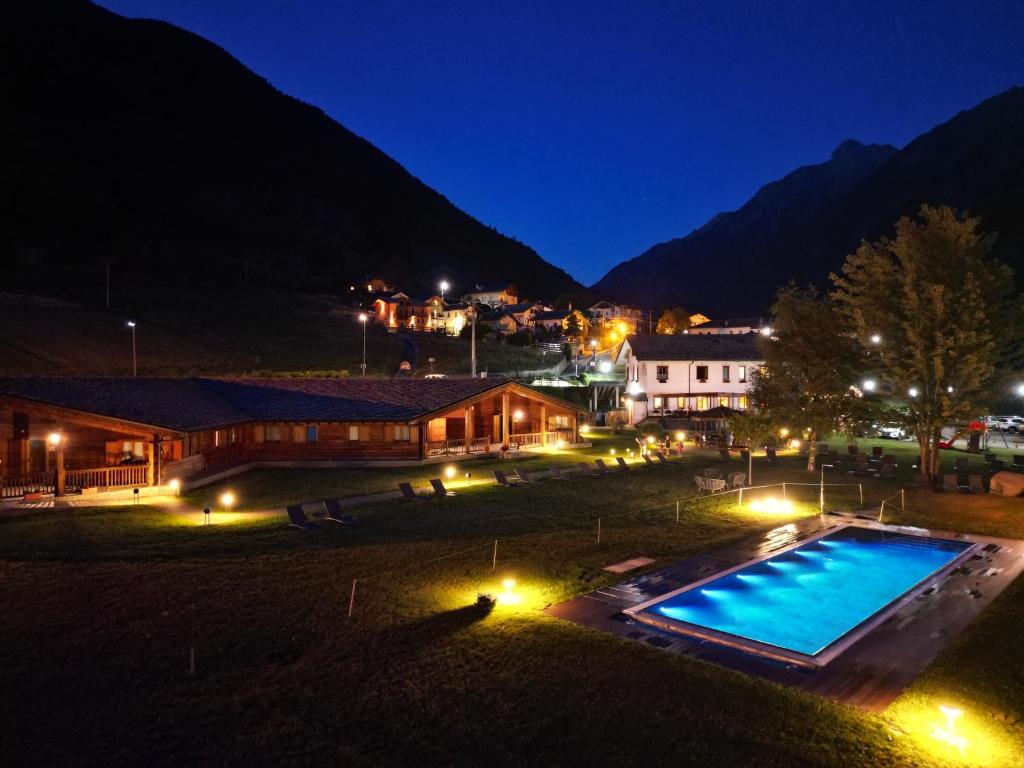 瓦尔佩利内丽维阿穆尔酒店的夜间带游泳池的度假村