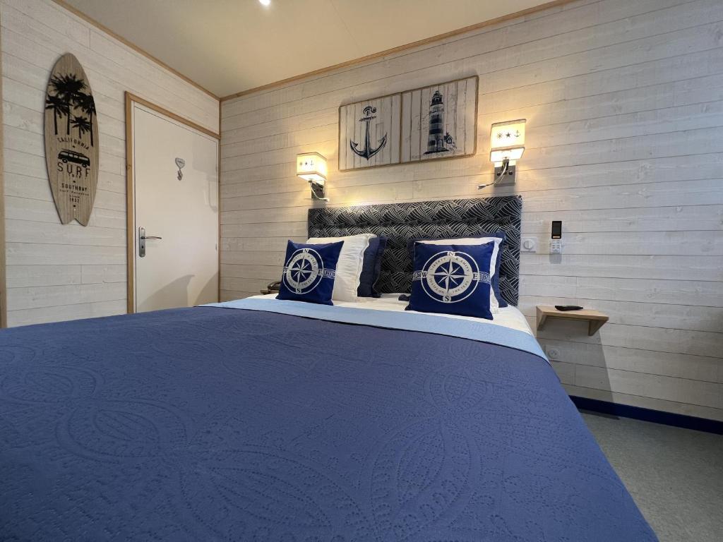 鲁雷特Domaine de Roullet的一间卧室配有一张带蓝色枕头的大床